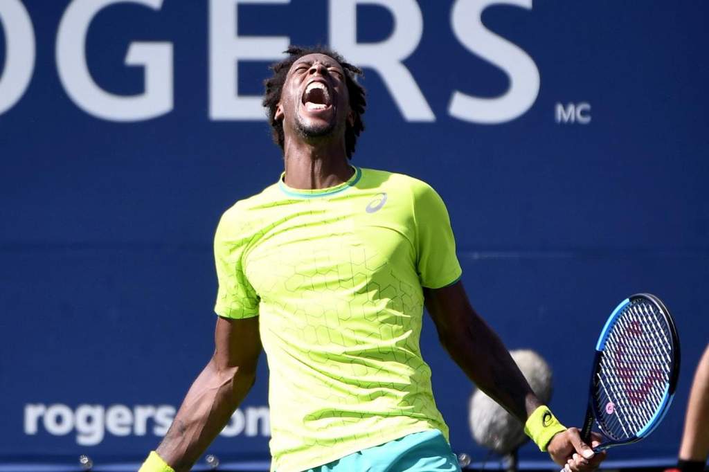 Professional tennis player waving to cheering crowds in stadium