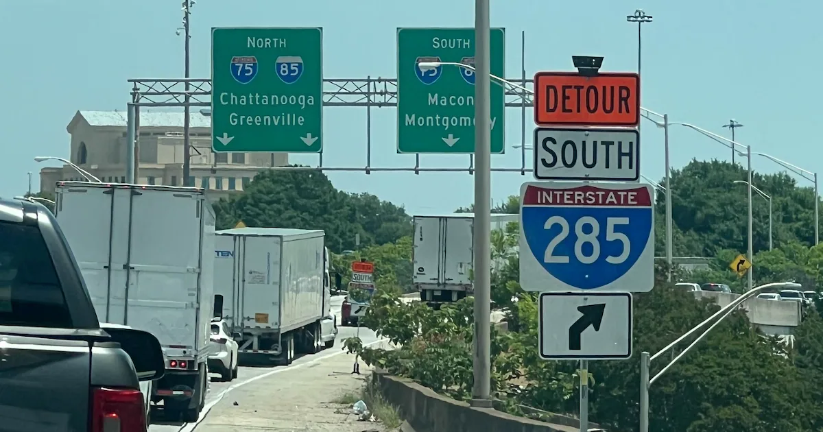 Heavy construction equipment and orange cones blocking a multi-lane highway