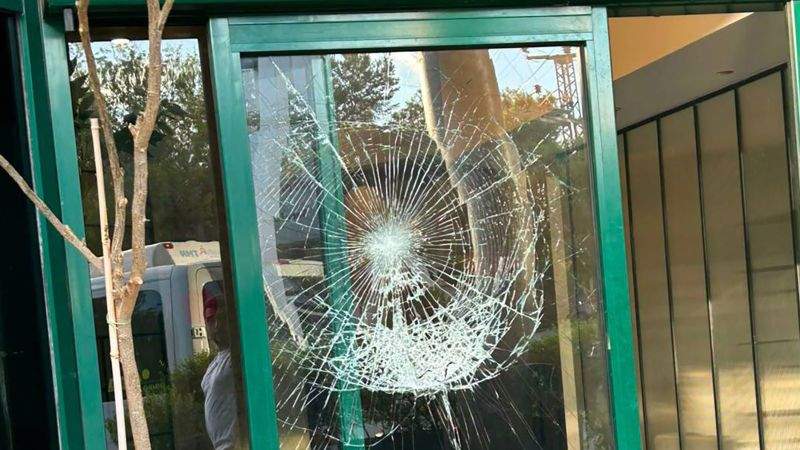 Broken glass door at a media headquarters after an attack