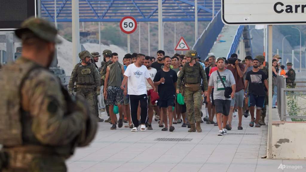 Migrants returning to Morocco from the Spanish enclave of Ceuta escorted by the Spanish army