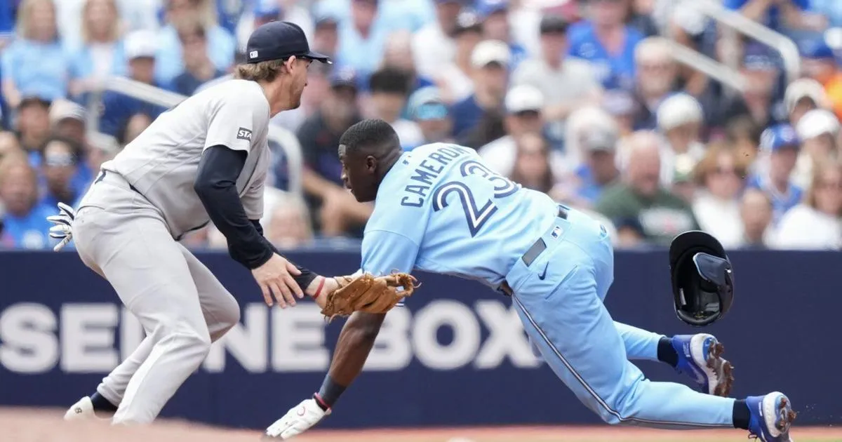 New York Yankees infielder Ryan McMahon tagging out Toronto outfielder Daz Cameron
