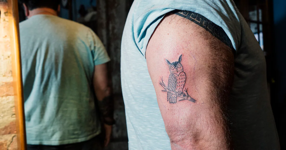 An older adult showing off tattoo body art on their arm
