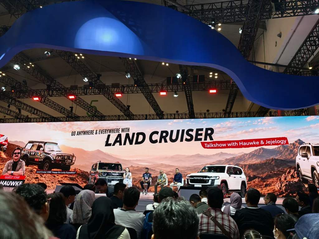 Classic and modern Toyota Land Cruiser vehicles on display at an auto exhibition